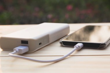 Güç banka üstünde okul sırası ile şarj mobil akıllı telefonlar.