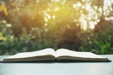 Açık kitap. Eski ahşap masa doğa arka plan üzerine açık kitap.