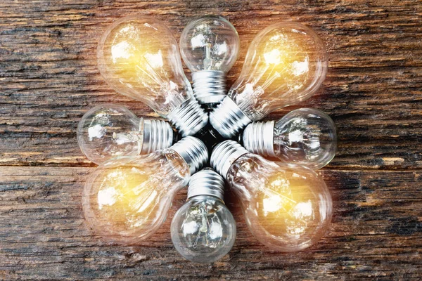 Lampadine con incandescenza su sfondo tavolo in legno. Idea, creatività e risparmio energetico con il concetto di lampadine . — Foto Stock