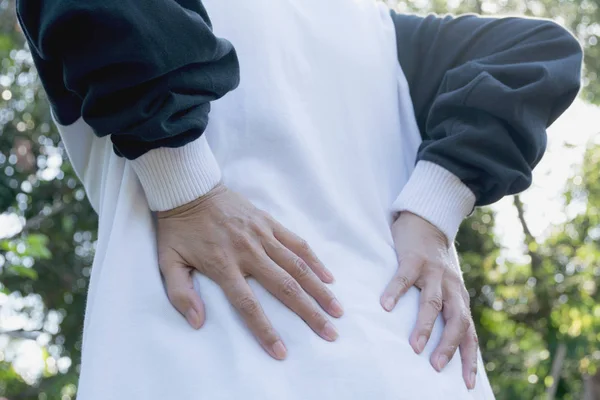 Mujer con las manos sosteniendo su cintura hacia atrás con dolor. Un concepto de dolor femenino . — Foto de Stock