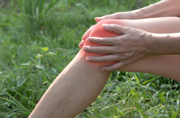 The guy clings to a bad leg. The pain in his leg after exercise. The pain is highlighted in red.