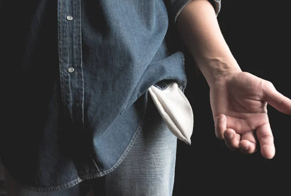 En mann som viser ingen penger ved å slå ut lommen. Tomme lommer . – stockfoto