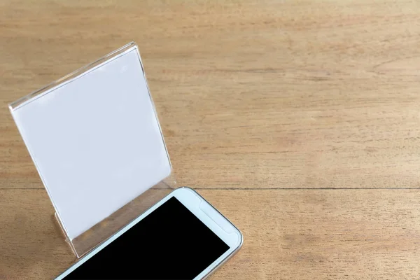 나무 테이블 배경에 흰 종이와 스마트 전화. 기술 및 통신 개념. — 스톡 사진
