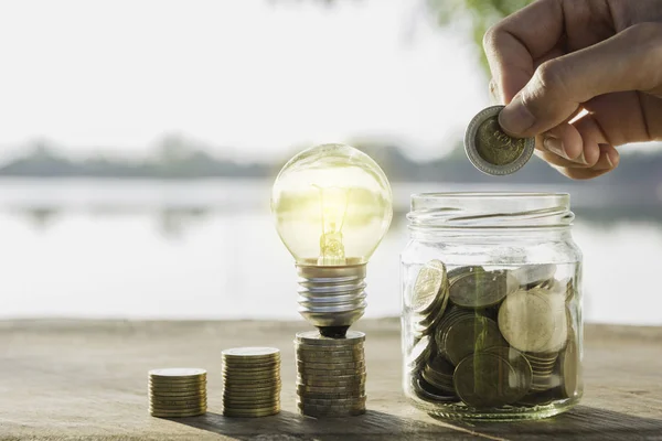 Saving money concept and hand putting money coin in the glass ja