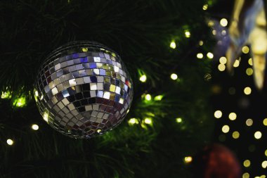 Dekoratif ışıkları ve bulanık ayna topuyla Noel ağacı