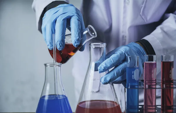 Pesquisador com tubos de ensaio químicos de laboratório de vidro com líquido — Fotografia de Stock