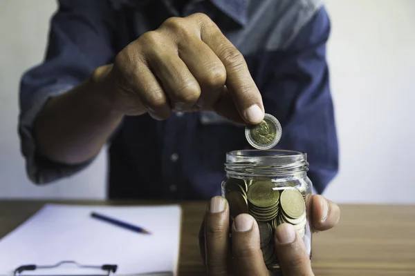 Hand drop a coin in glass jar for business. Financial and accoun