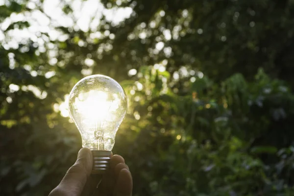 El concepto de innovación y energía de la mano sostiene una bombilla y copia — Foto de Stock