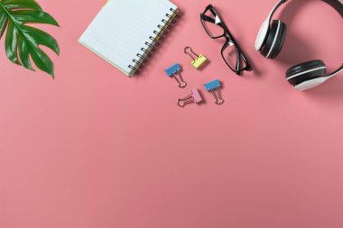 Üst görünümü klavye ve pembe arka planda not defteri. Dağınık ofis masası geçmişi.