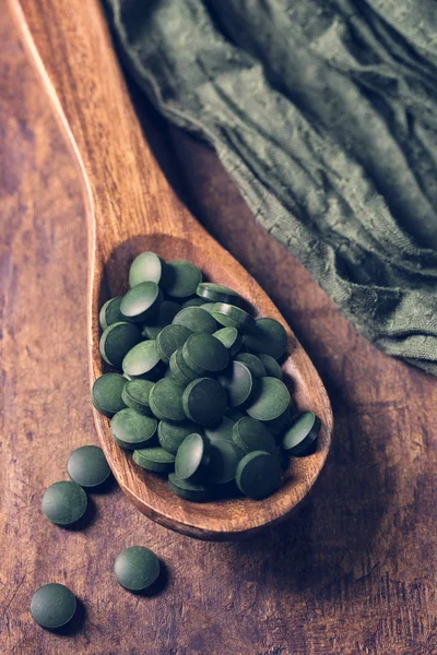 Tabletas de espirulina en una cuchara — Foto de Stock