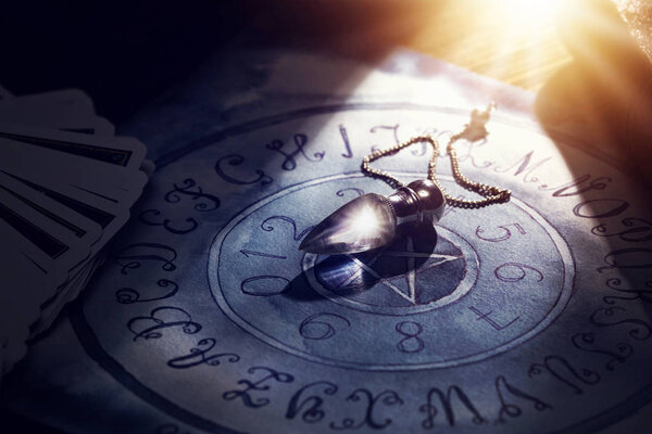 Кристаллический маятник на доске
