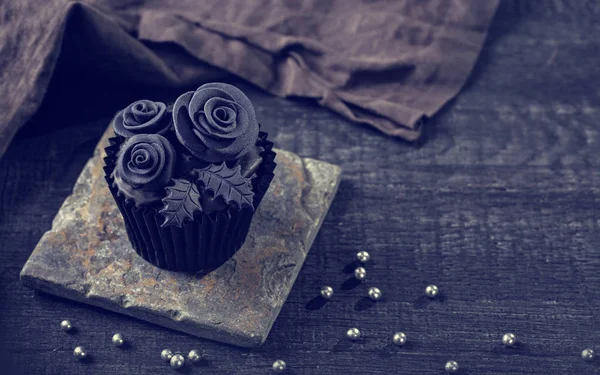 Black cupcakes on a wooden background — Stock Photo, Image