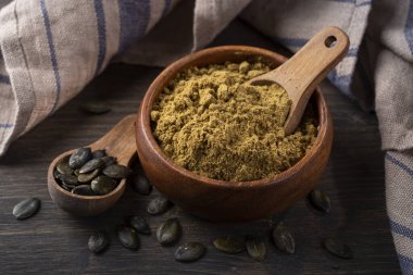 Pumpkin seed flour in a wooden bowl isolated on a white background