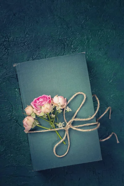 粉红色的花和蓝色背景的旧书 — 图库照片