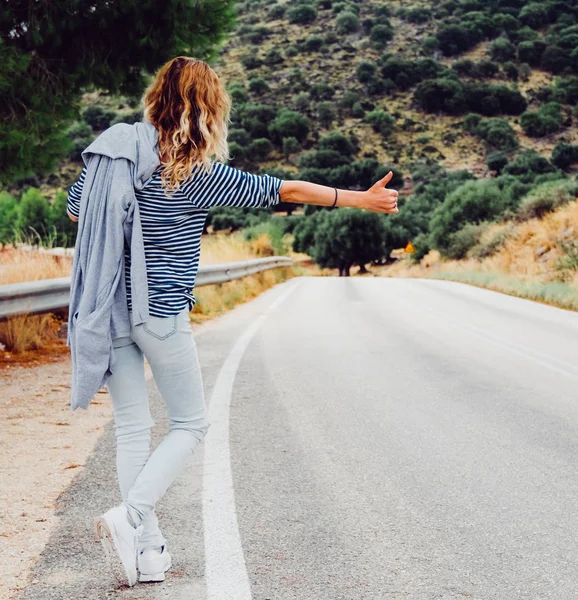 Mujer autostop a lo largo de la carretera . — Foto de Stock