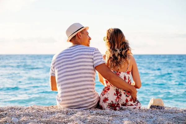 Junges verliebtes Paar sitzt am Strand — Stockfoto