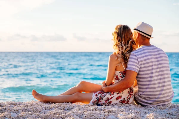 Jovem casal apaixonado sentado na praia — Fotografia de Stock