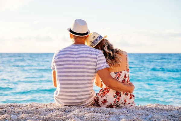 Pareja joven enamorada sentada en la playa — Foto de Stock