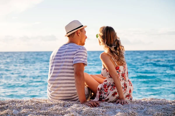 Jong paar in liefde zitten op het strand — Stockfoto