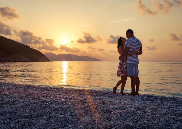 Jovem casal apaixonado sentado na praia — Fotografia de Stock