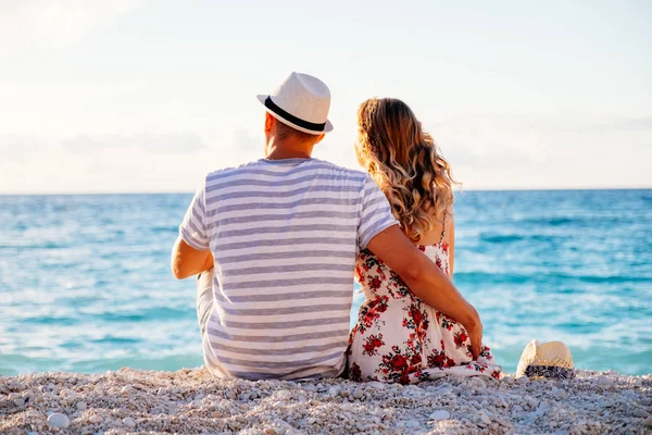 Junges verliebtes Paar sitzt am Strand — Stockfoto