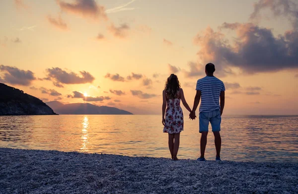 Pareja joven enamorada sentada en la playa —  Fotos de Stock