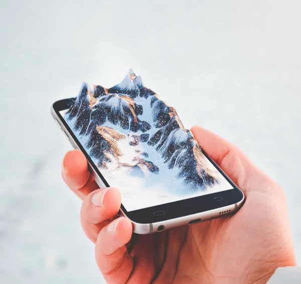 Человек держит смартфон с горами на экране . — стоковое фото