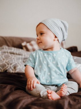 Sevimli küçük mutlu bebek kız bir yatakta bir odada oturan çalış. Mutlu aile eğleniyor.