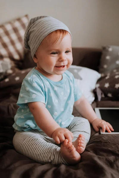 Schattig klein happy babymeisje speelt zittend op een bed in een kamer. Gelukkige familie plezier. — Stockfoto