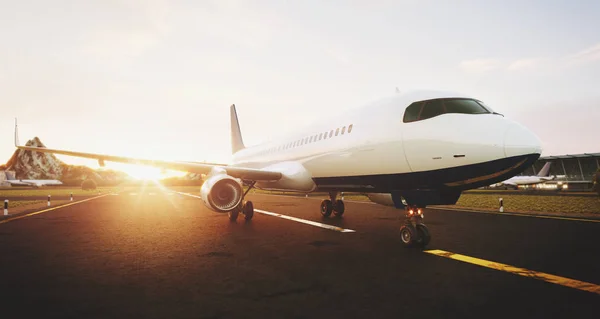 Білий комерційний літак, що стоїть на злітно-посадковій смузі аеропорту на заході сонця. Злітає вид спереду пасажирського літака. Концепція літака 3D ілюстрація . — стокове фото