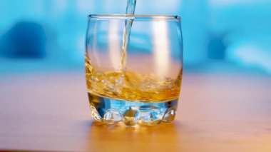 Whisky is poured into glass. Slow motion