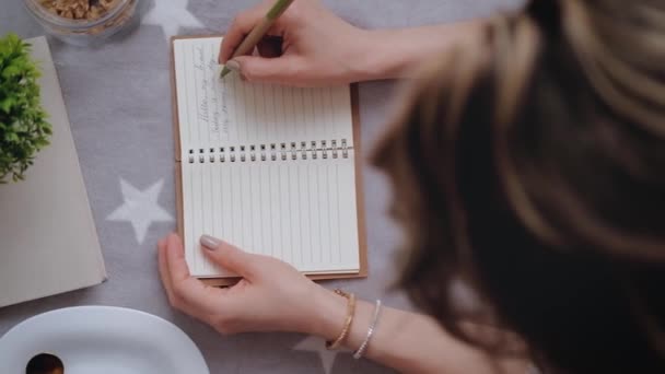 Молодая женщина делает записи в своем дневнике . — стоковое видео