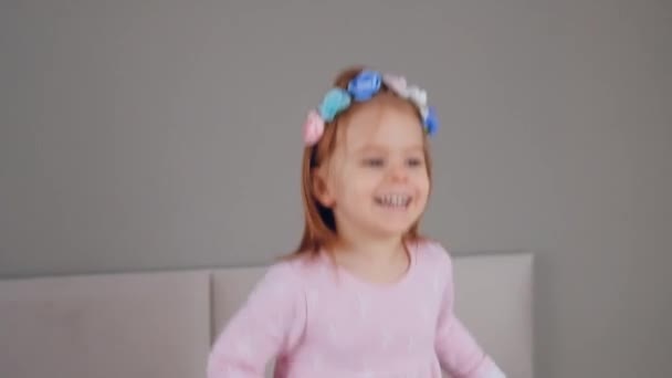 Słodkie szczęśliwy mała dziewczyna skoków na łóżku — Wideo stockowe
