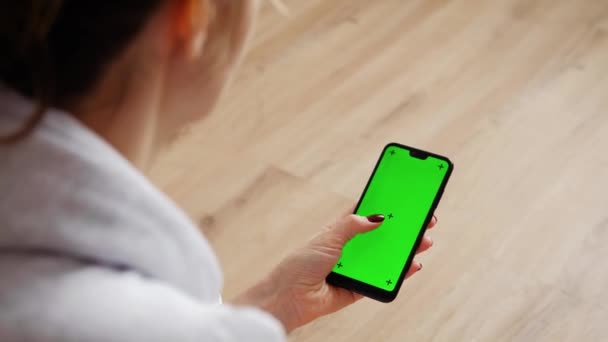 Mujer joven usando el teléfono inteligente sentada en el sofá en casa. — Vídeo de stock