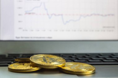Fotoğraf altın Bitcoins laptop ve grafik arka plan. Kripto Döviz Ticaret kavramı