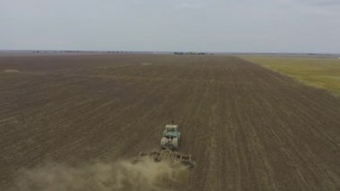 Aerial view tractor plows a large field