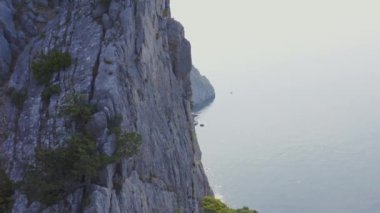 Gökyüzü manzaralı deniz ve kaya ön planda dağcı ile birlikte. Kırım