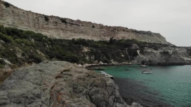 Mavi şeffaf su ve resiflerle kayalık deniz manzarası