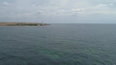 Sahilde deniz ve deniz feneri manzaralı. Tarhankut, Kırım