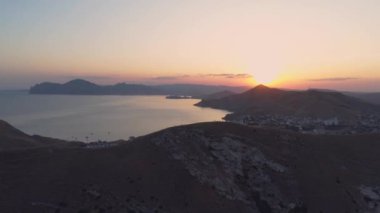 Gökyüzü manzaralı insanlar en tepedeki dağda gün batımını izlerler.