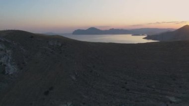 Hava manzaralı şehir, gün batımında dağ sırasının ötesindeki şehir.