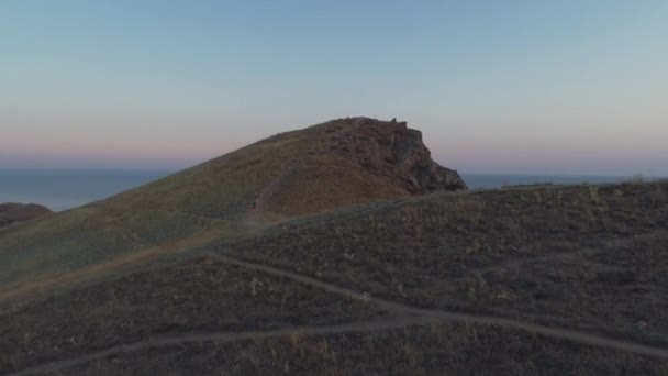 Vue aérienne fille dans la crête de montagne se lève. Le drone avance 