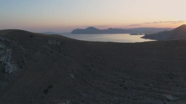 Vue aérienne ville la ville au-delà de la chaîne de montagnes pendant le coucher du soleil 