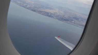 Uçak irtifa kazanıyor. Pencereden uçağın manzarası. Pencerenin dışındaki deniz