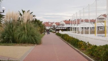 İnsanlar kışın tropik bir şehirde yürür ve bisiklet sürerler.