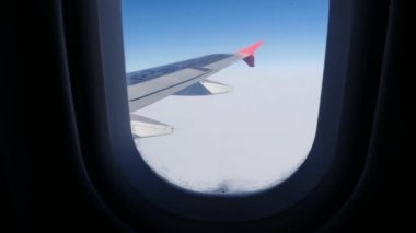 Uçak bulutların üzerinde uçuyor. Pencereden uçuyor.