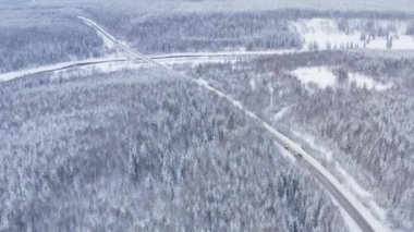 Karla kaplı bir ormanda nehir manzaralı kuzey karayolu.