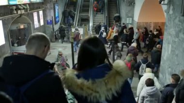 İnsanlar asansörle metroya iniyor. Arkadan görünüm