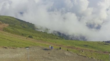 Havadan bakan insanlar bulutlarla inanılmaz dağlara bakıyor.