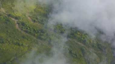 Gökyüzü manzaralı bulutlar yeşil dağların üzerinde süzülür